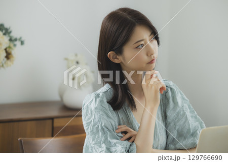 部屋でパソコンを見る女性 129766690