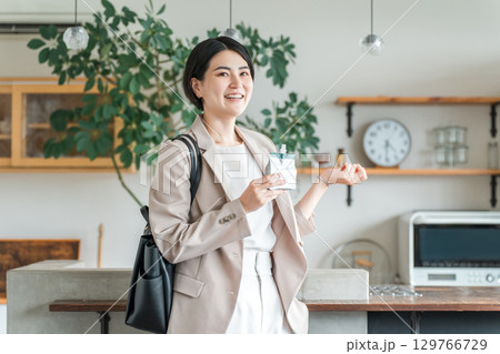 朝食,間食で栄養補助食品,栄養補助ゼリーを食べるスーツ姿の若いアジア人女性 朝食,間食で栄養補助食品,栄養補助ゼリーを食べるスーツ姿の若いアジア人女性 129766729