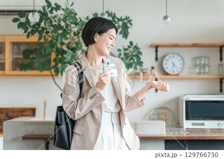 朝食,間食で栄養補助食品,栄養補助ゼリーを食べるスーツ姿の若いアジア人女性 朝食,間食で栄養補助食品,栄養補助ゼリーを食べるスーツ姿の若いアジア人女性 129766730
