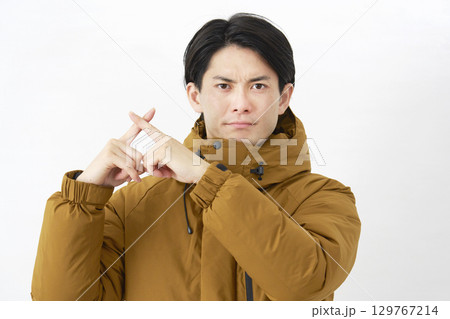 ダウンジャケットを着た男性　バツ印のジェスチャー　白背景 129767214