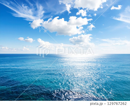 Blue waves reflect the summer sunlight, painting a serene seascape where the ocean meets the horizon under a vast, cloudy sky Blue waves reflect the summer sunlight, painting a serene seascape where the ocean meets the horizon under a vast, cloudy sky 129767262