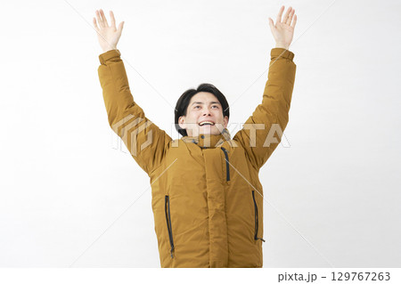 ダウンジャケットを着た男性　伸び　白背景 129767263