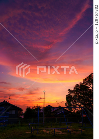 住宅街の夕焼け 紅色に染まった爆焼けの空 灯りが灯った街灯と紅色に染まる公園 住宅街の夕焼け 紅色に染まった爆焼けの空 灯りが灯った街灯と紅色に染まる公園 129767882