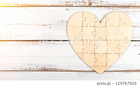 A vintage paper card with a textured heart shape on an old wooden background, perfect for a Valentine's Day design 129767920