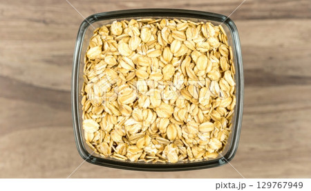 Dry raw organic oatmeal and buckwheat cereal grains in glass jars on a white background 129767949