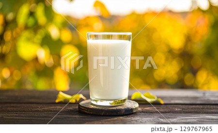 Glass of cold, fresh milk on a wooden table Glass of cold, fresh milk on a wooden table 129767965