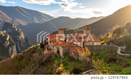 Landscape view of a picturesque European mountain village with a church and houses, overlooking the sea Landscape view of a picturesque European mountain village with a church and houses, overlooking the sea 129767968