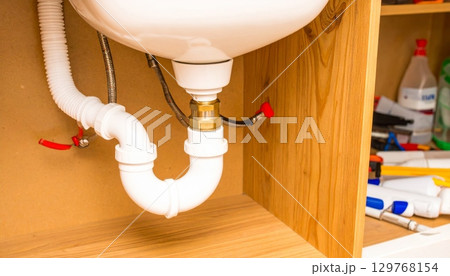 Worker installs new parquet wooden floor inside a house under new home construction 129768154