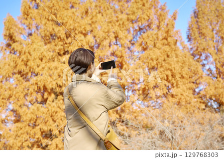 紅葉の写真を撮影する女性　ミドルエイジ　後ろ姿 129768303