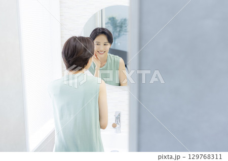 スキンケアをする洗面所の女性 スキンケアをする洗面所の女性 129768311