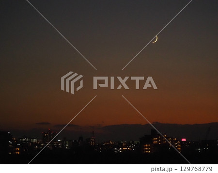 夕暮れの空に浮かぶ月齢1.9の月 129768779