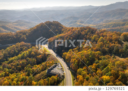 Freeway road with fast moving traffic cars and trucks in North Carolina Appalachian mountains in fall season. Interstate transportation infrastructure in USA 129769321