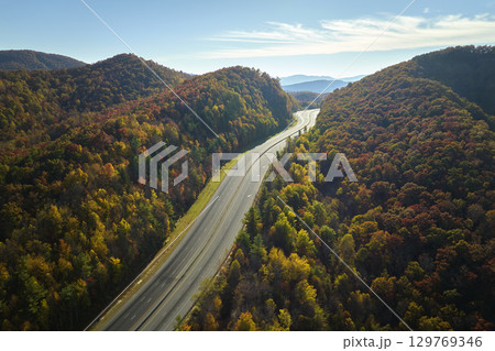 Aerial view of empty I-40 freeway in North Carolina leading to Asheville through Appalachian mountains in golden fall season. Energy crisis and high gas prices concept 129769346
