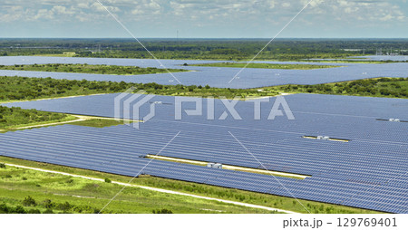 Aerial view of large sustainable electrical power plant with rows of solar photovoltaic panels for producing clean electric energy. Concept of renewable electricity with zero emission 129769401