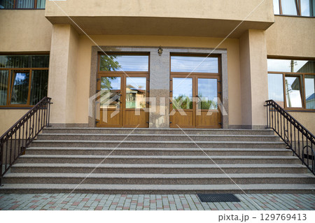 Detail of a house facade. New granite stairs with metal railings. Detail of a house facade. New granite stairs with metal railings. 129769413