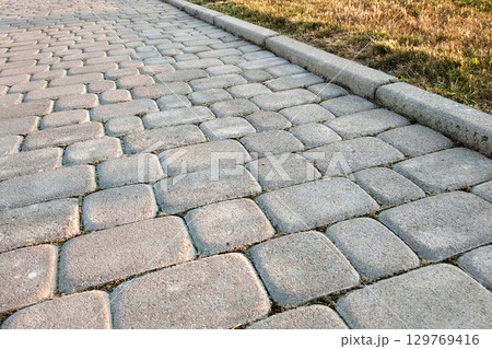 Close-up of slab stone paved path way at park or backyard. Walkway footpath road at house yard garden. Close-up of slab stone paved path way at park or backyard. Walkway footpath road at house yard garden. 129769416