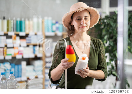 Woman buyer select sunscreen cream 129769798
