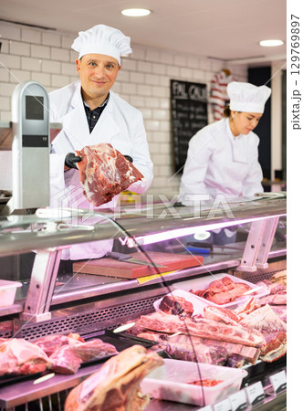 Young male butcher showing big piece of beef meat in butchery 129769897