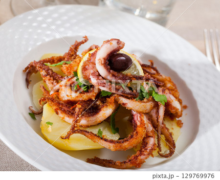 Fried tentacles squid with potatoes 129769976