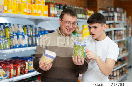 Man with son discussing choice of green and yellow split peas in supermarket Man with son discussing choice of green and yellow split peas in supermarket 129770392
