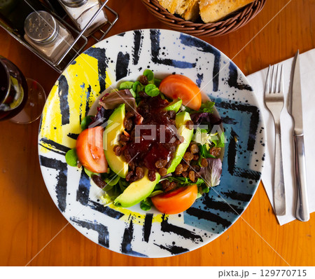 Fresh salad with avocado, raisins and strawberry jam 129770715