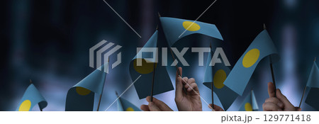 Palau flags in their hands on a blurred urban background 129771418