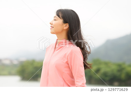 公園の水際で佇む女性 公園の水際で佇む女性 129771629