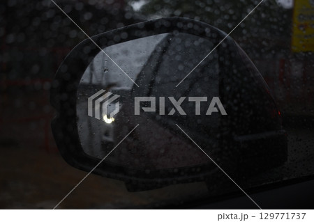 side mirror of car in rainy day, water drop on glass side mirror of car in rainy day, water drop on glass 129771737