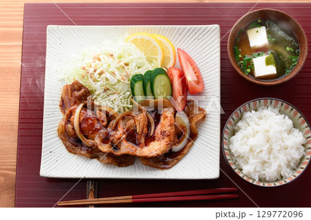 出来立て熱々の豚の生姜焼き定食　湯気が立つジューシーな豚肉とキャベツ添えの和食ランチ 129772096