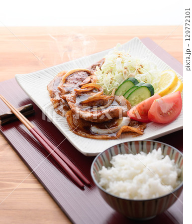出来立て熱々の豚の生姜焼き定食　湯気が立つジューシーな豚肉とキャベツ添えの和食ランチ 129772101