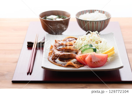 出来立て熱々の豚の生姜焼き定食　湯気が立つジューシーな豚肉とキャベツ添えの和食ランチ 129772104