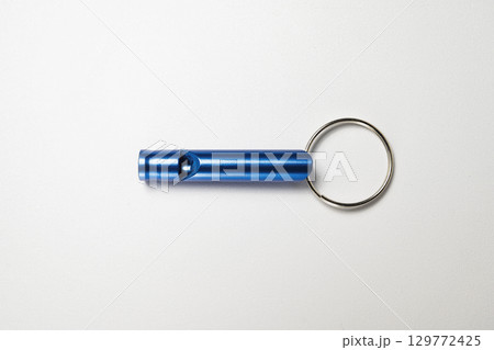 Closeup view of a blue whistle isolated over a white background 129772425