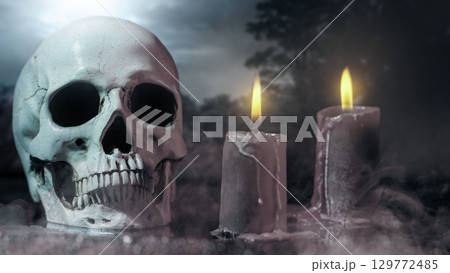 Human head skull with fire candles for ritual at a scary night scene background. Concept of Spooky Halloween 129772485