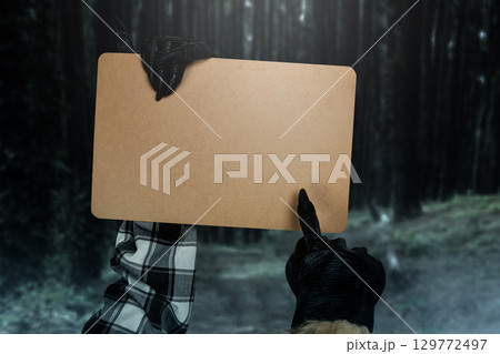 Werewolf hands showing a piece of brown paper with a night scene background. Monster, devil, evil, satan, or zombie hands. Mockup or Copy space. Concept of Spooky Halloween 129772497