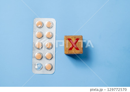 Closeup view of medicine tablet pills in a blister pack with a blue background. Concept of healthcare and medicine Closeup view of medicine tablet pills in a blister pack with a blue background. Concept of healthcare and medicine 129772570