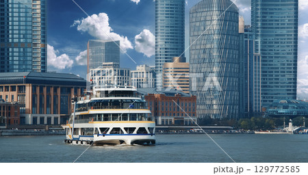 Cruise liner gliding along modern waterfront lined with skyscrapers. Shanghai, China Cruise liner gliding along modern waterfront lined with skyscrapers. Shanghai, China 129772585
