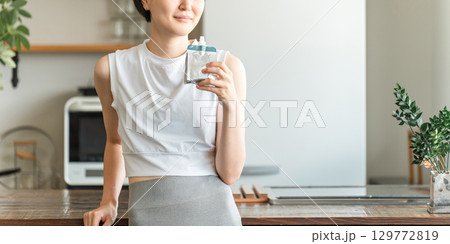 ゼリー飲料,栄養補助ゼリーで栄養補給するスポーツウェア姿の若いアジア人女性 129772819