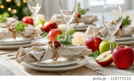 Festive holiday table setting with apples, candles, and elegant decor. Festive holiday table setting with apples, candles, and elegant decor. 129773510