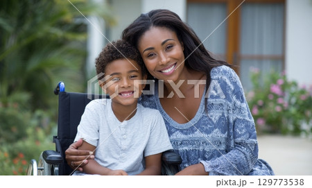 Smiling african family: happy mother and child embrace in a garden setting. 129773538