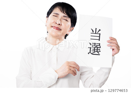 当選と書かれた紙を持ち喜ぶ中年女性 当選と書かれた紙を持ち喜ぶ中年女性 129774653