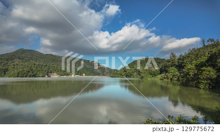 Peaceful Lake Scene Surrounded by Lush Green Hills 129775672