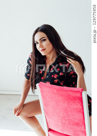 Portrait of a beautiful woman in a black flower dress with a smile 129775958