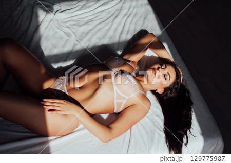 Fashionable photo of young lady wearing white lingerie, amazing body. 129775987