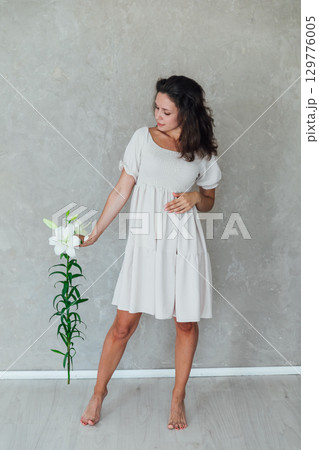 woman with funeral lily flowers on white background woman with funeral lily flowers on white background 129776005