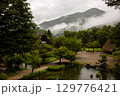 夏の雨に包まれた白川郷の池と合掌造りの古民家 129776421