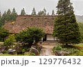 夏の雨に包まれた白川郷の古民家と緑豊かな木々 129776432
