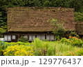 夏の雨に濡れる白川郷の合掌造り古民家と緑の庭 129776437