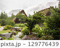 夏の雨に濡れた白川郷の合掌造りの家と庭園風景 129776439