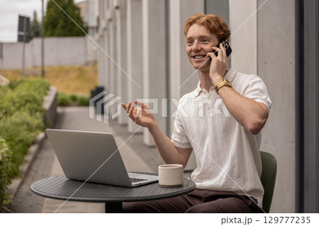 Online man worker discussing business issue on smartphone while working on pc computer Online man worker discussing business issue on smartphone while working on pc computer 129777235