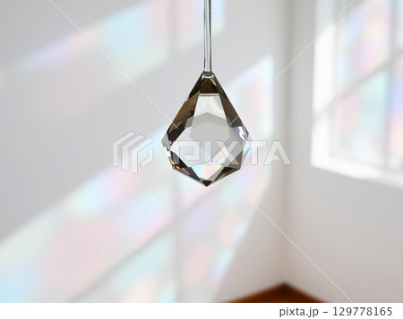Crystal prism hanging, refracting light into rainbow patterns 129778165